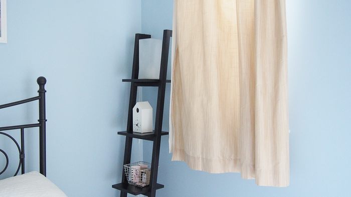 corner of the bedroom with a lamp, clock, and candles